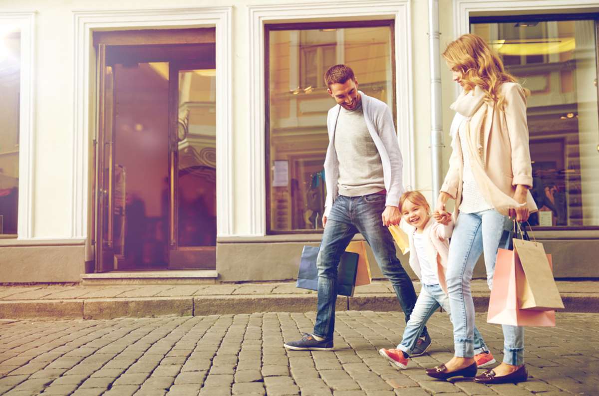 happy family with little child and shopping bags in city