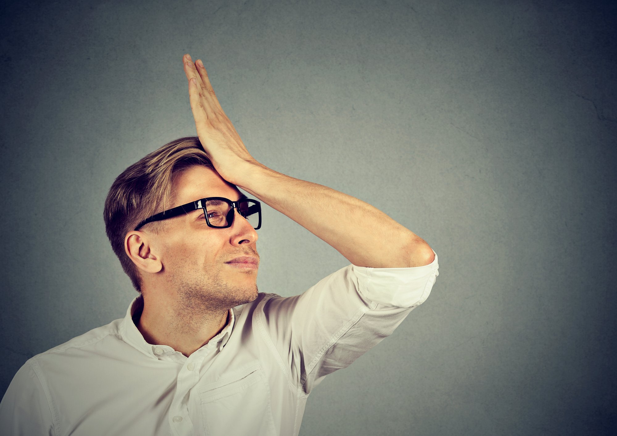 Silly man slapping hand on head having duh moment