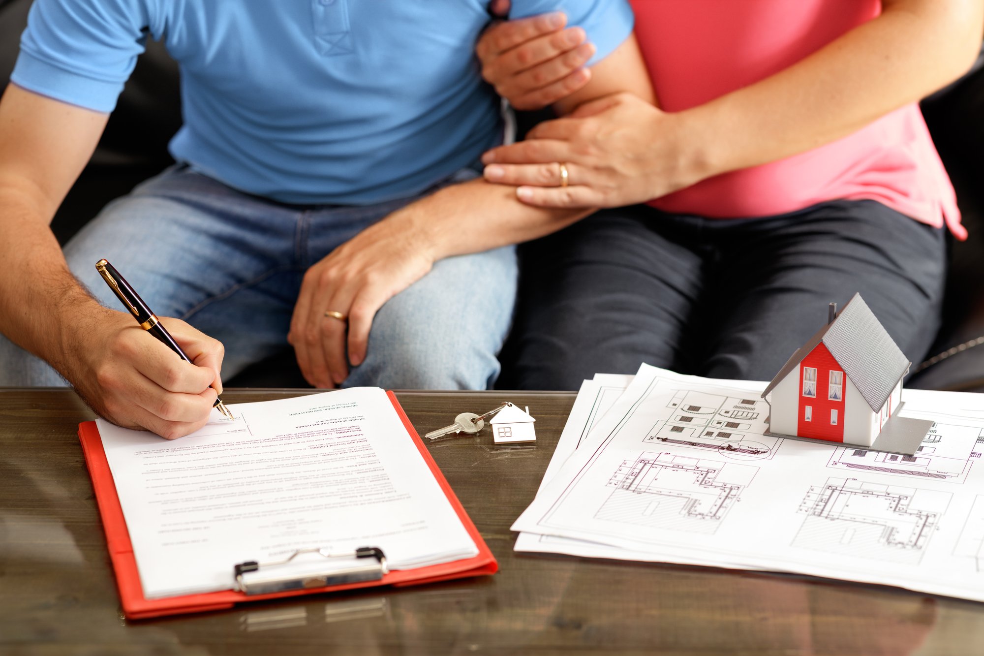 Young Couple Signing Loan Contract For House Purchasing